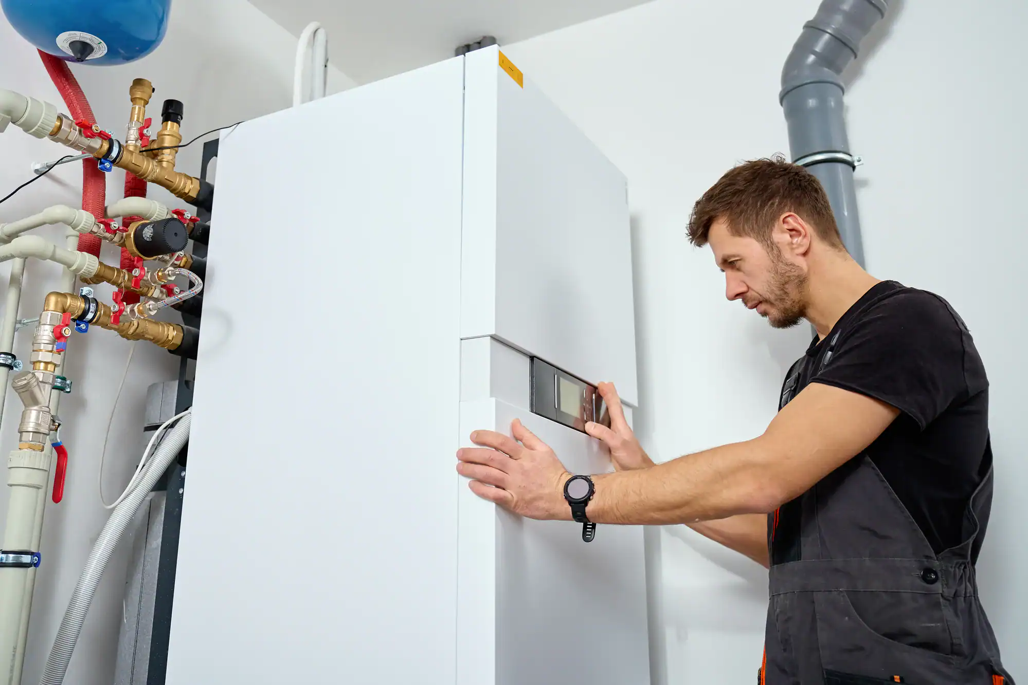 Technician wearing a black watch installing a heat pump in Essex County, New Jersey